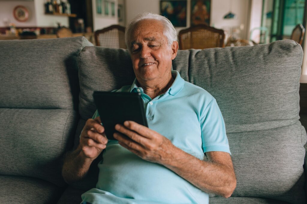 israeli lifestyle for reitred - retiree holding an ipad smiling