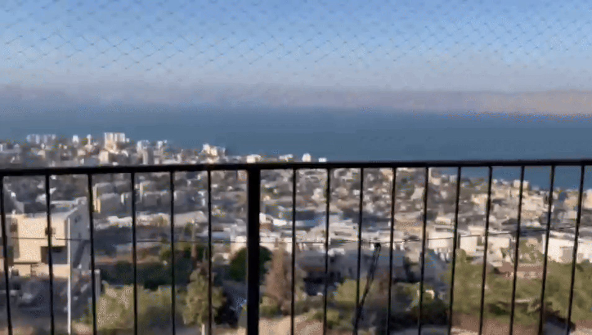 Cityscape by the sea from a balcony view.