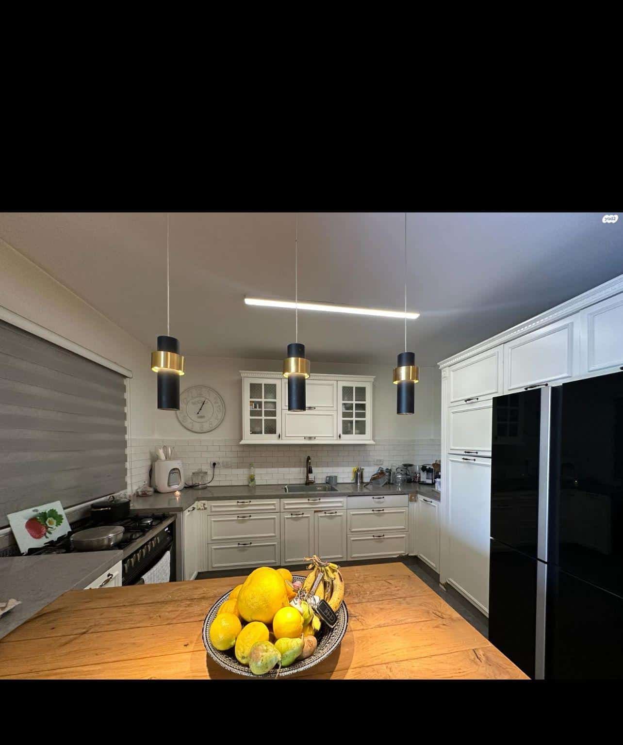 Modern kitchen interior with island and fruit bowl.