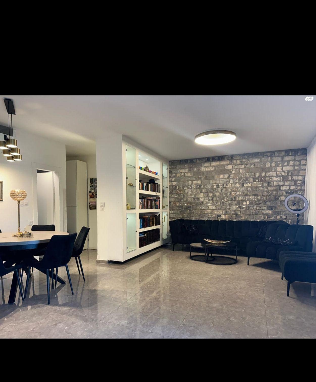 Modern living room with brick accent wall and furniture.