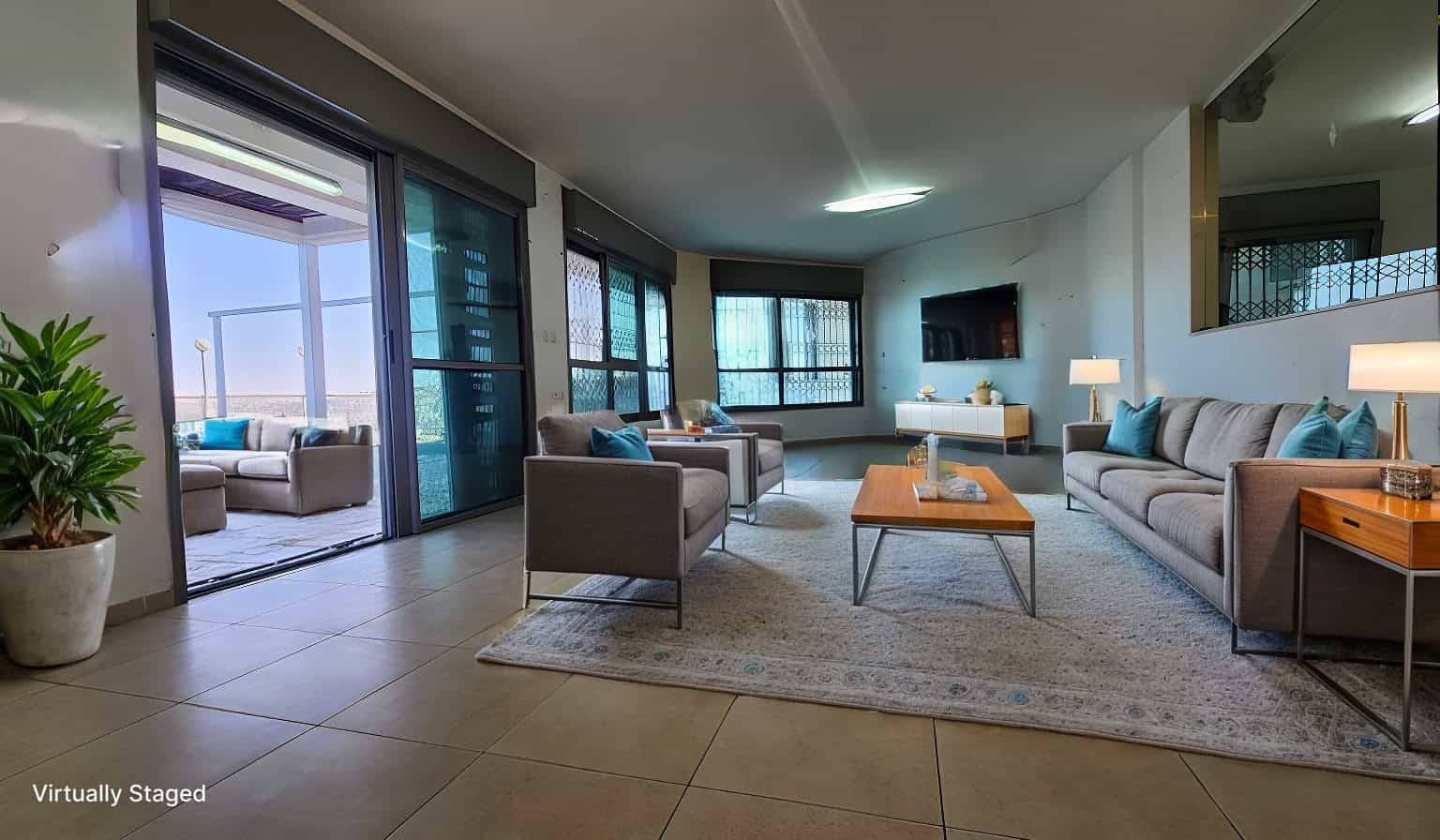 Modern living room with blue accents and balcony access.
