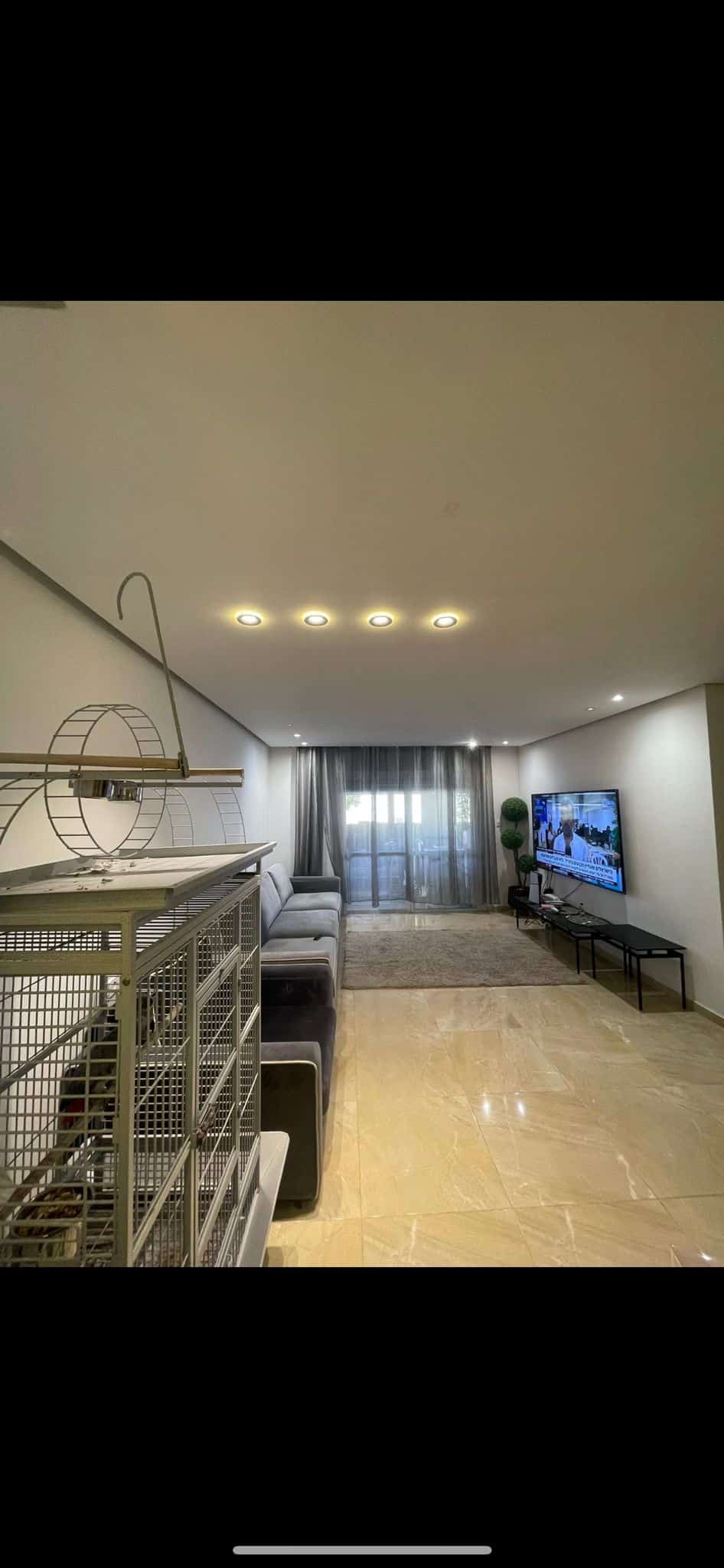 Modern living room with TV and comfortable seating area.