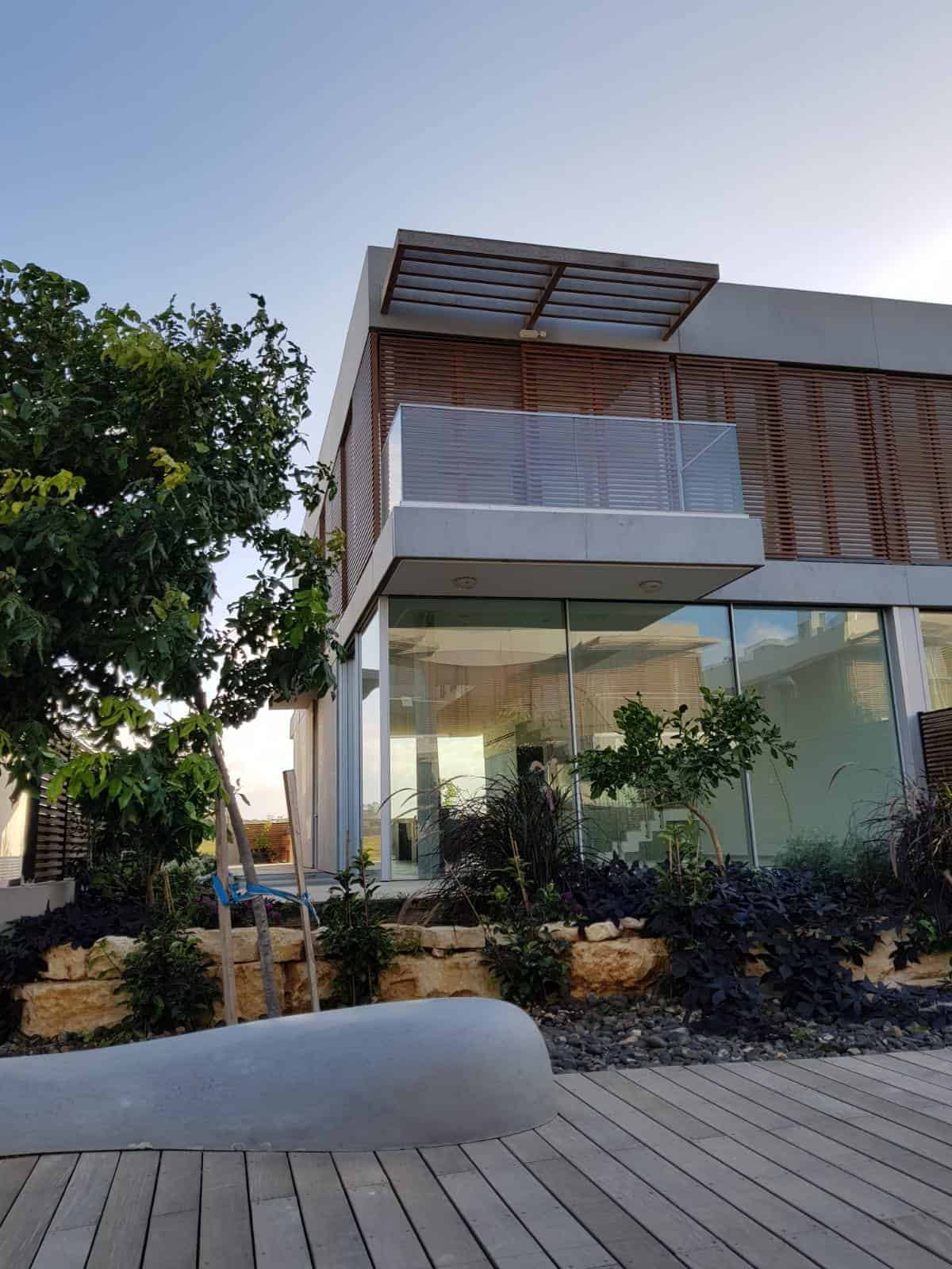 Modern home with garden and wooden deck outside.