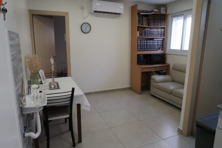 Small dining area with sink and chair nearby.