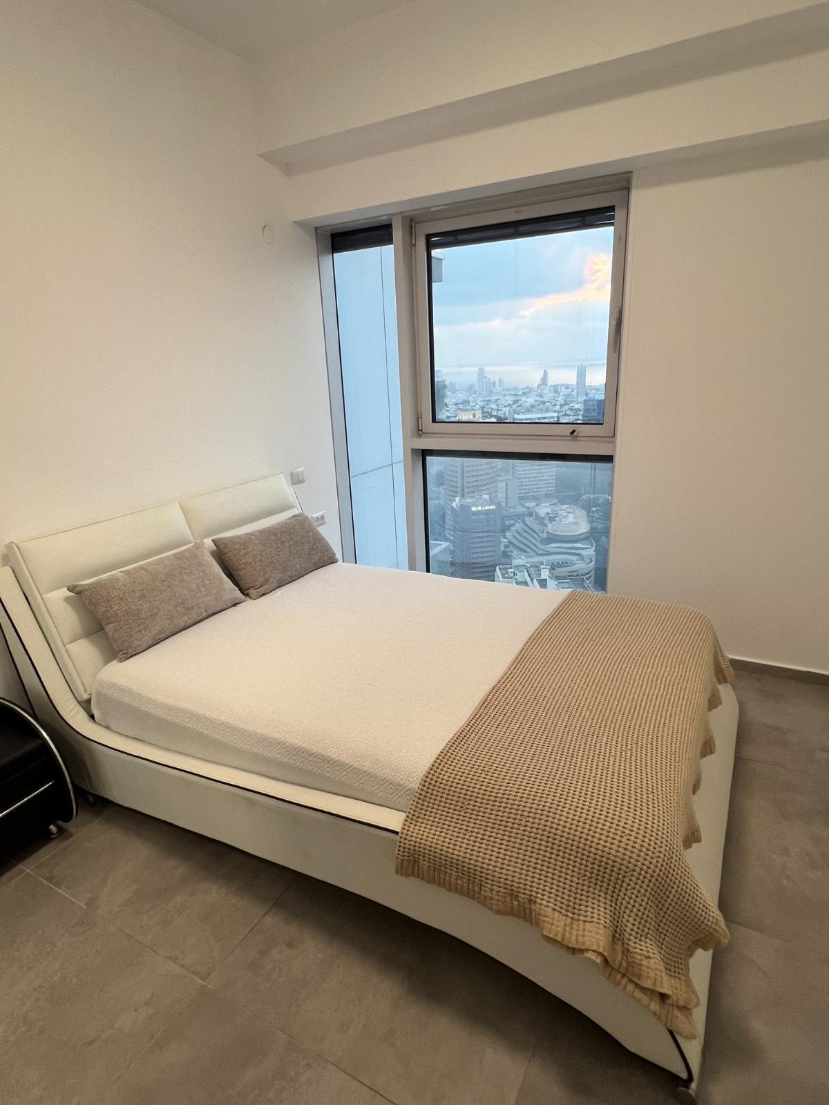 Bedroom with large window at the Midtown Tel Aviv apartment