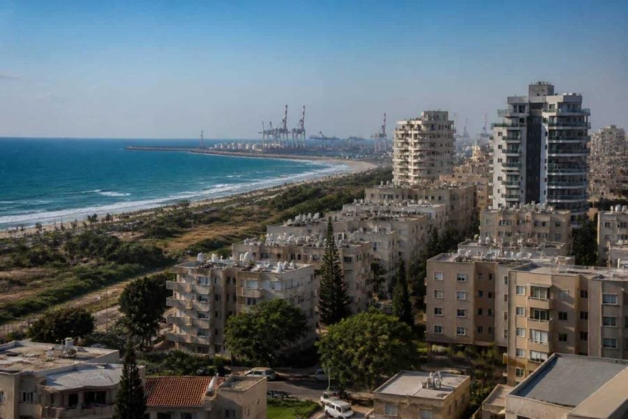Modern apartment buildings near the Ashdod coastline with the port area in the distance