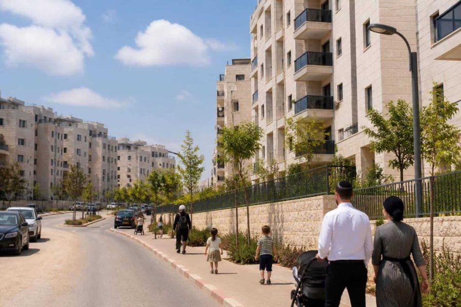 Modern residential apartment buildings in Beit Shemesh with families walking nearby