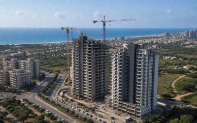 Modern residential towers and construction cranes near the Hadera coastline
