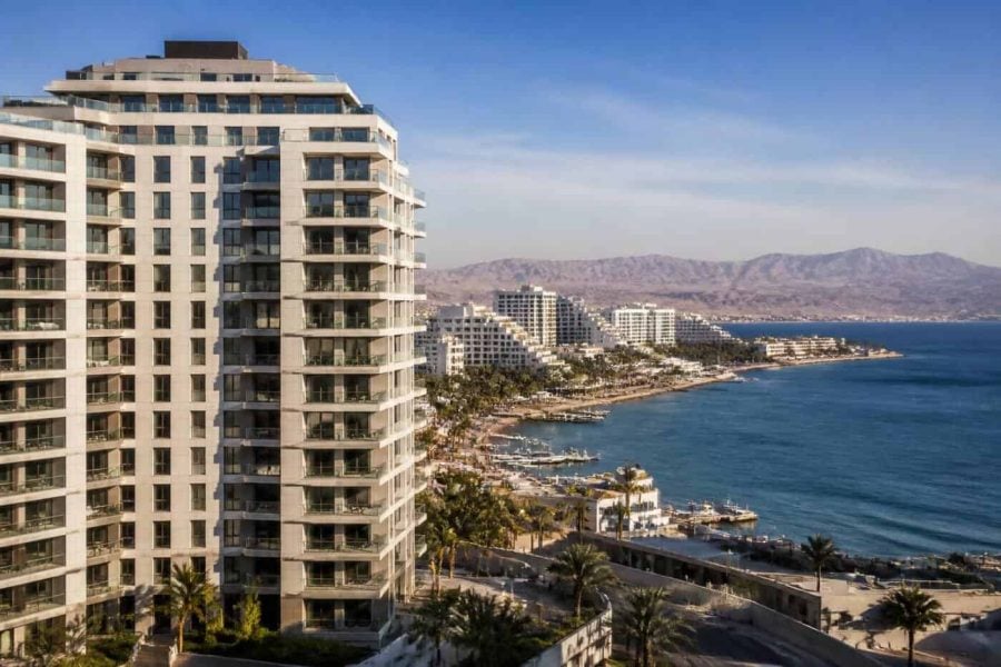 Modern apartment buildings near the Eilat waterfront with beaches and resort hotels in the background