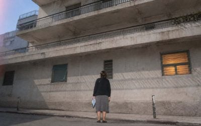 concrete shadows and quiet observation of a building in israel by an old lady