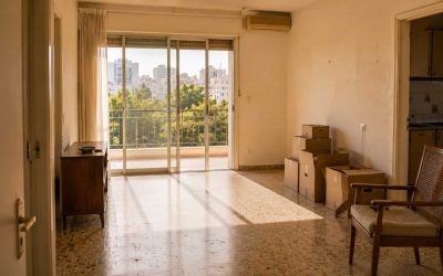 Quiet empty older Israeli apartment with sunlight suggesting an inherited-sale opportunity