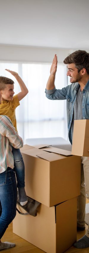 Family unpacking cardboard boxes at new home