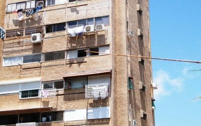Haifa apartment block whose balconies have been added and closed in with different railings, awnings and window frames