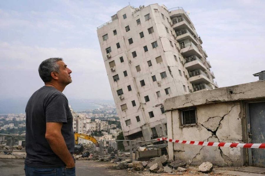Exterior view of the tilting residential building in Haifa showing structural damage
