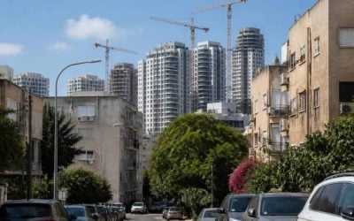 Modern apartment buildings and construction cranes in an Israeli city during a calm real estate market