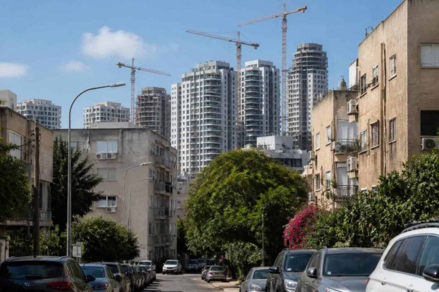 Modern apartment buildings and construction cranes in an Israeli city during a calm real estate market