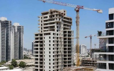 Apartment buildings under construction in an Israeli city with cranes and residential towers