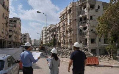 War-damaged residential buildings in Israel awaiting reconstruction with planners and barriers nearby