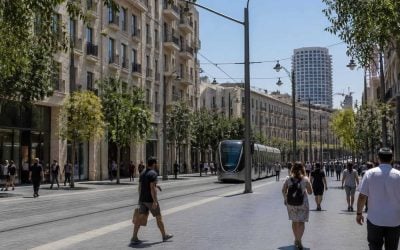 Pedestrians and light rail on Jaffa Street in central Jerusalem near residential buildings