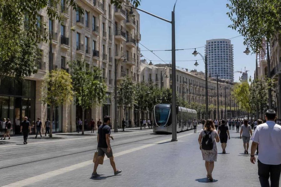 Pedestrians and light rail on Jaffa Street in central Jerusalem near residential buildings