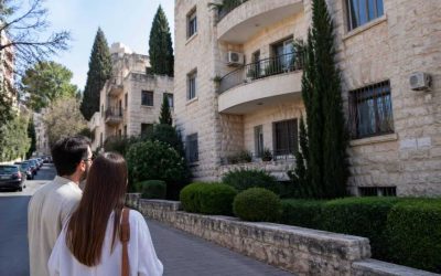 Tree-lined Jerusalem residential street with stone apartment buildings and balconies