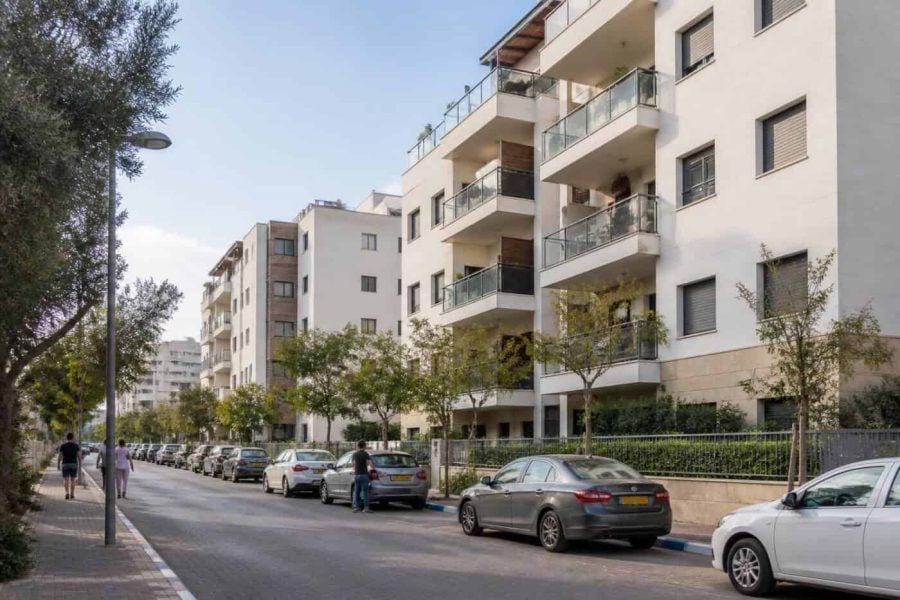 Modern apartment buildings and a tree-lined street in Kfar Saba
