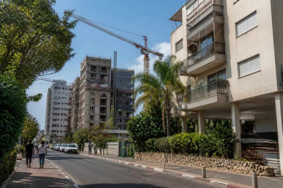 Apartment buildings and construction cranes in a residential Israeli neighborhood undergoing urban renewal