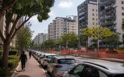 Residential apartment buildings in a central Israel suburb with modern streets and public transit construction nearby