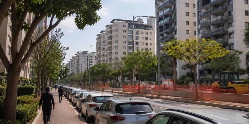 Residential apartment buildings in a central Israel suburb with modern streets and public transit construction nearby