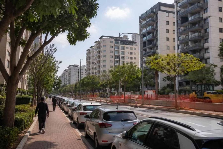 Residential apartment buildings in a central Israel suburb with modern streets and public transit construction nearby