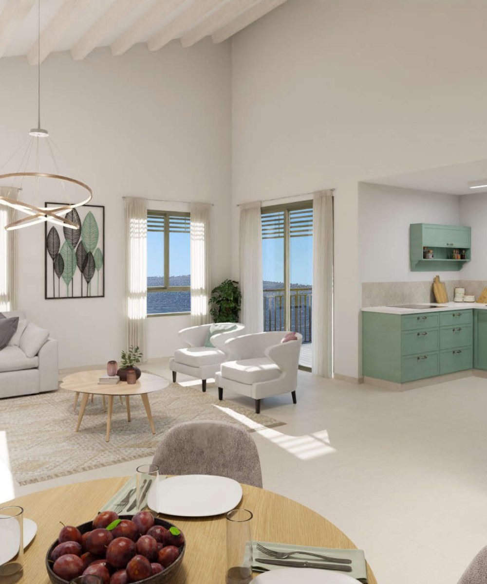 A modern living room with white walls, a large window overlooking the ocean, and a dining table with plates and fruit.