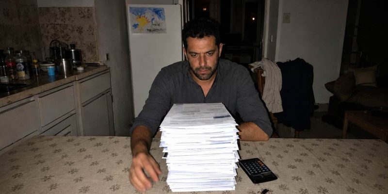 man facing paperwork in the kitchen