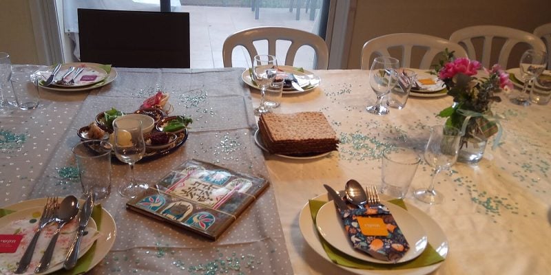 Table set for a Passover seder with matzah, a seder plate and a Haggadah