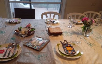 Table set for a Passover seder with matzah, a seder plate and a Haggadah