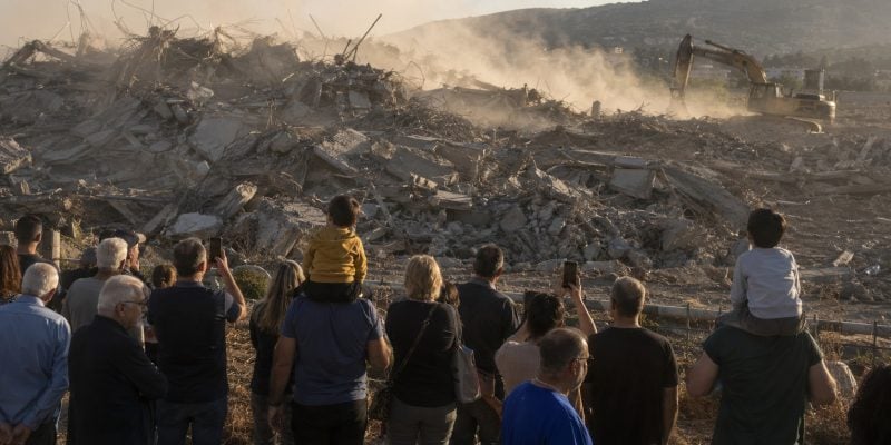 people looking at a demolishing site in israel
