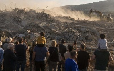 people looking at a demolishing site in israel