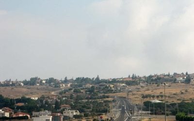 Houses on the dry ridge of Poria Illit, south of the Sea of Galilee, with a road in the foreground.