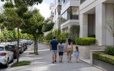 Family walking through a quiet residential street with apartment buildings and greenery in Ra’anana