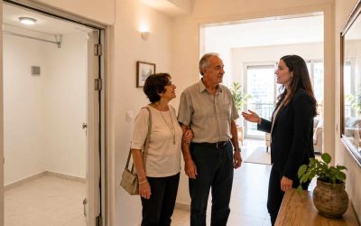 Retired couple viewing a practical Israeli apartment with easy access and a protected-room feel
