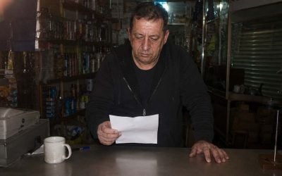 reviewing arnona bill in a cluttered shop