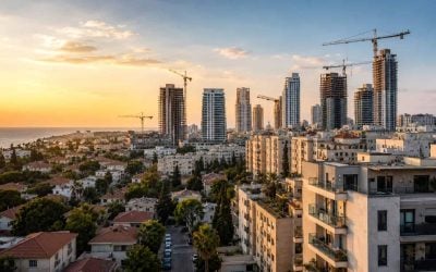 Israeli city skyline with apartment towers, construction cranes, and residential neighborhoods at sunset, showing the country's active real estate market.