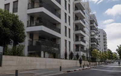 Modern Tel Aviv apartment building with balconies viewed from a quiet residential street