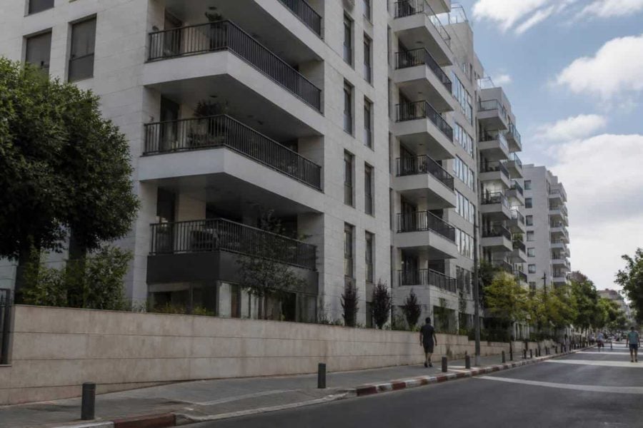 Modern Tel Aviv apartment building with balconies viewed from a quiet residential street