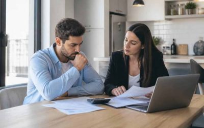 A prospective homebuyer reviews mortgage documents and housing costs with a real estate professional in a modern apartment