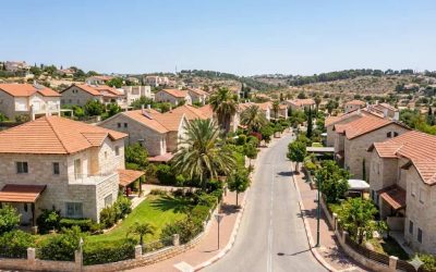 The image depicts a serene residential area with a wide, straight road running through it. The houses are uniformly designed with red-tiled roofs and white walls, creating a cohesive architectural...