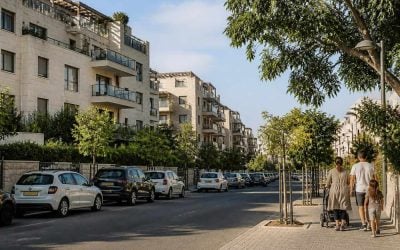Israeli residential street with apartment buildings parking trees and families walking