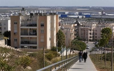 Modest apartment buildings near an industrial area in Kiryat Gat during the day