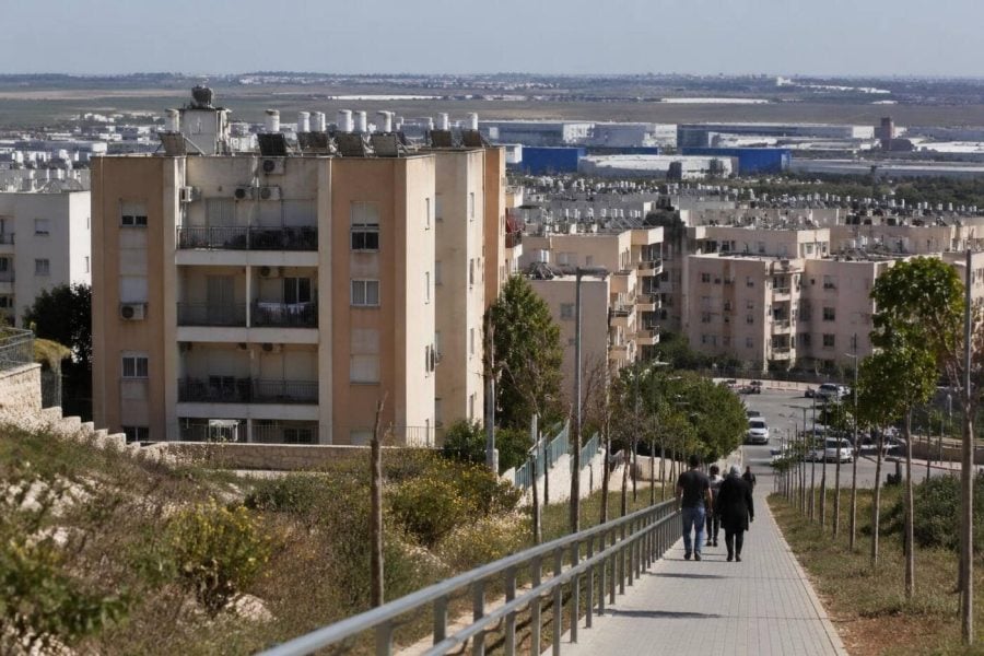 Modest apartment buildings near an industrial area in Kiryat Gat during the day